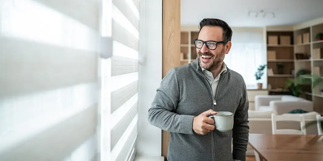 Man at home smiling with morning coffee, exploring GLP-1 weight loss options with Thrive