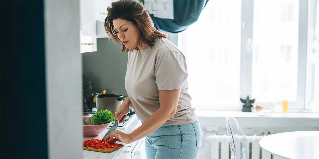 woman cutting vegetables in kitchen