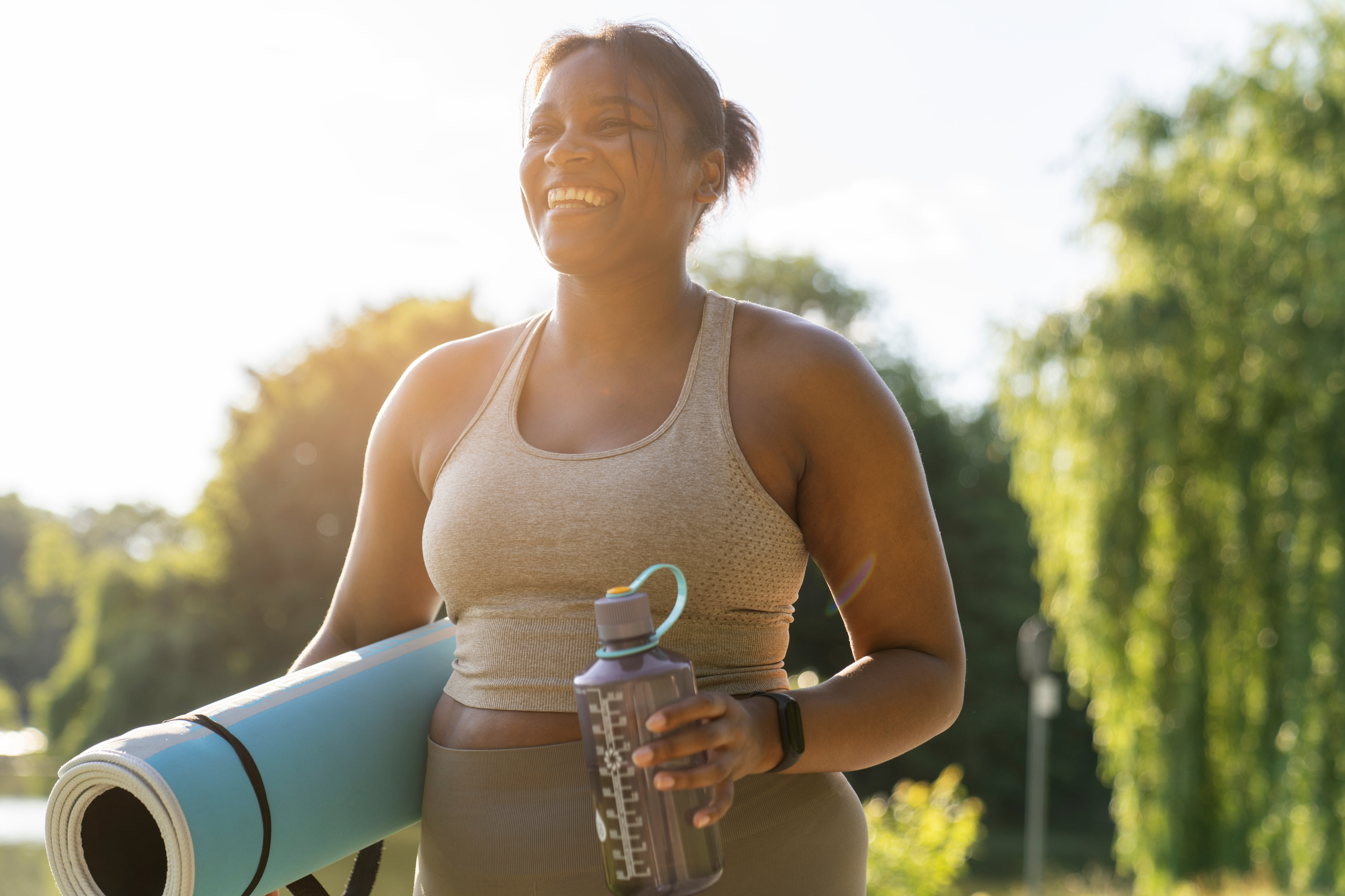 woman walking outside with yoga mat