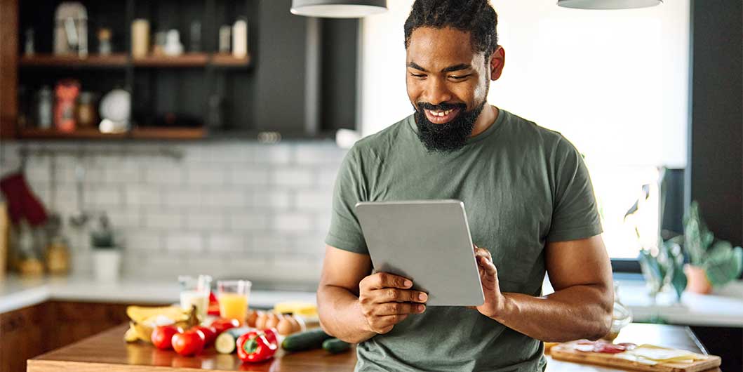 Man on ipad in kitchen