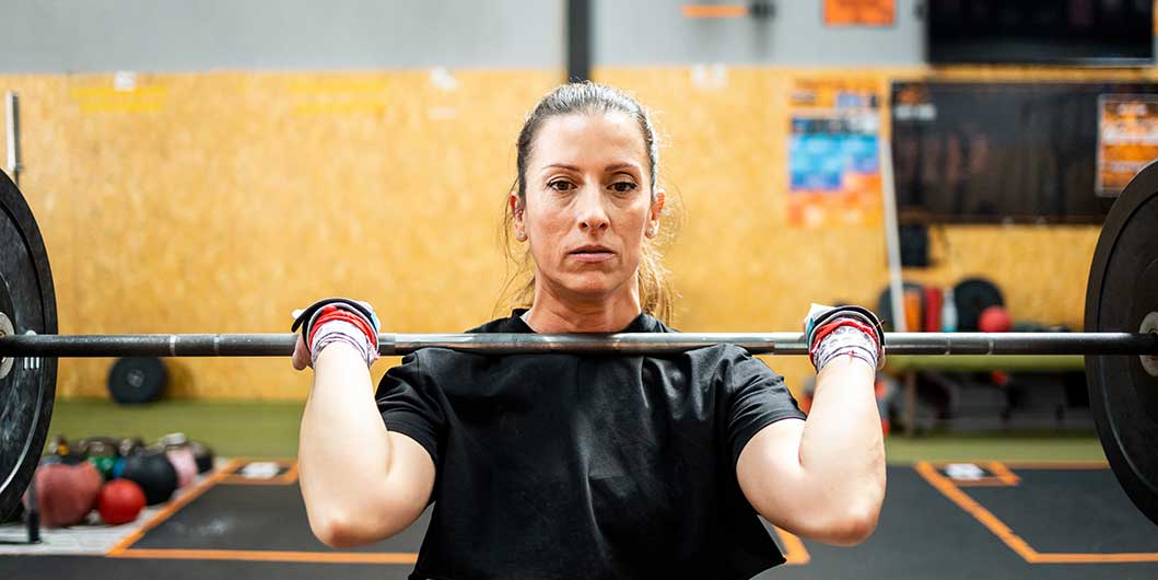 Female lifting barbell in gym